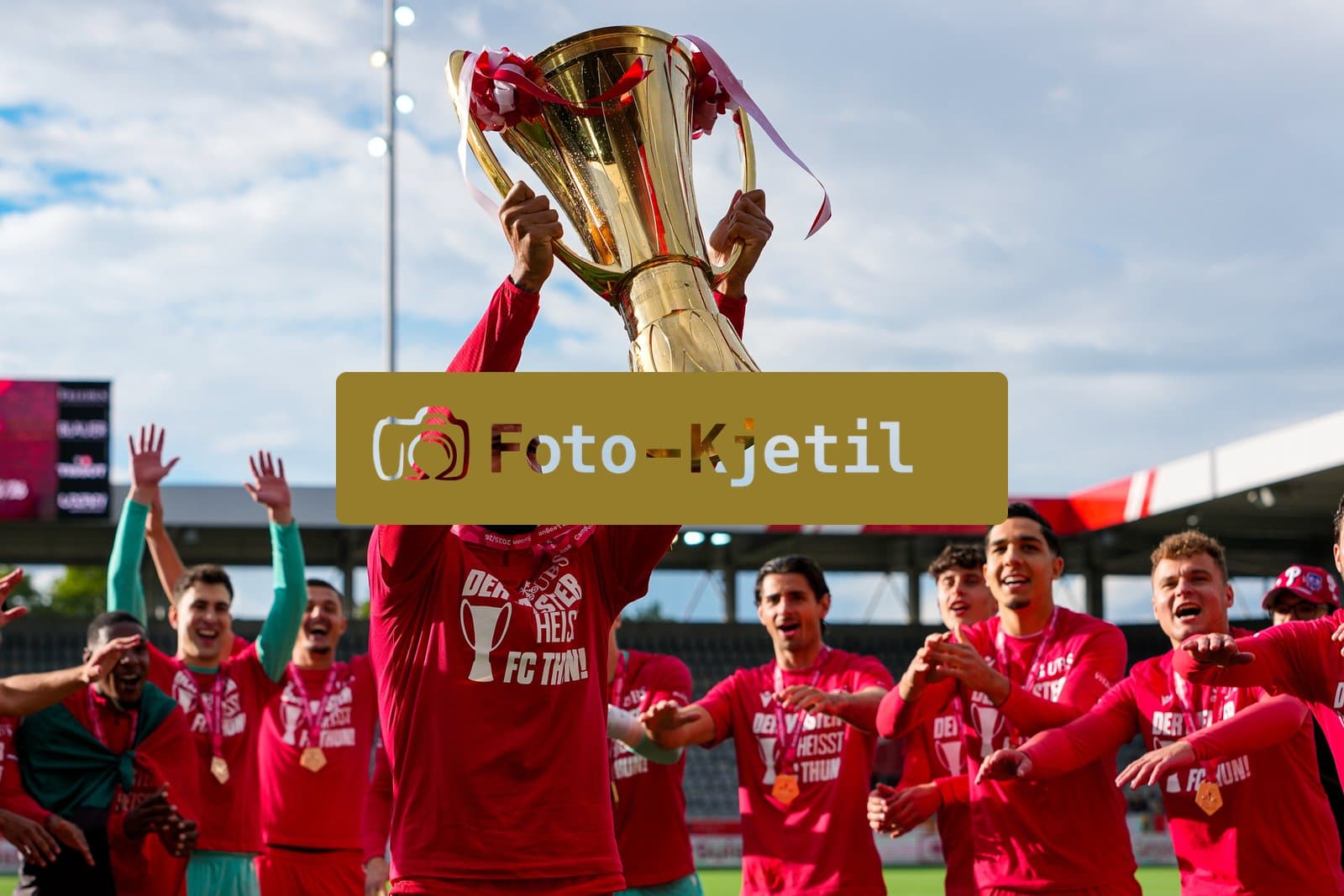 Schweiz: Brack Super League 2025/2026, FC Thun vs BSC Young Boys - Stockhorn Arena, Thun: FC Thun als Schweizer Meister 2026 nach dem letztjährigen Aufstieg in die höchste Schweizer Liga, ist zum ersten mal in der Klubgeschichte Meister. Christopher Ibayi (18 THU) mit dem Pokal vor den Fans