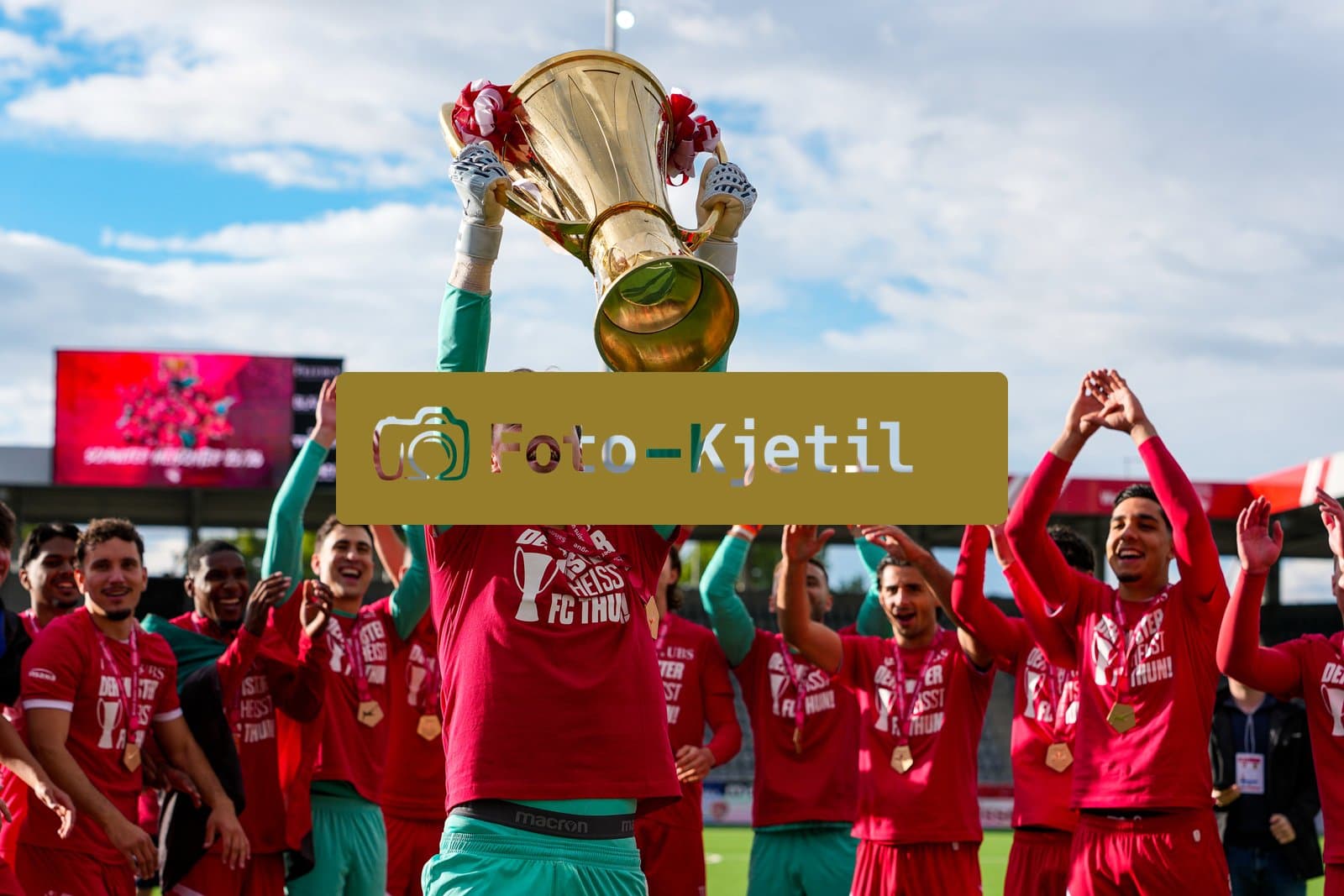 Schweiz: Brack Super League 2025/2026, FC Thun vs BSC Young Boys - Stockhorn Arena, Thun: FC Thun als Schweizer Meister 2026 nach dem letztjährigen Aufstieg in die höchste Schweizer Liga, ist zum ersten mal in der Klubgeschichte Meister. Tim Spycher (Torhüter 25 THU) mit dem Pokal vor den Fans