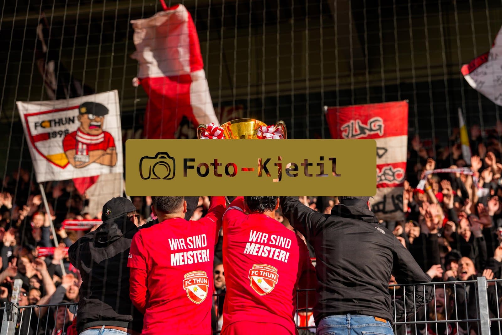 Schweiz: Brack Super League 2025/2026, FC Thun vs BSC Young Boys - Stockhorn Arena, Thun: FC Thun als Schweizer Meister 2026 nach dem letztjährigen Aufstieg in die höchste Schweizer Liga, ist zum ersten mal in der Klubgeschichte Meister. Leonardo Bertone (6 THU) gemeinsam mit Marco Bürki - Marco Burki (23 THU) mit dem Pokal vor den Fans der Fankurve